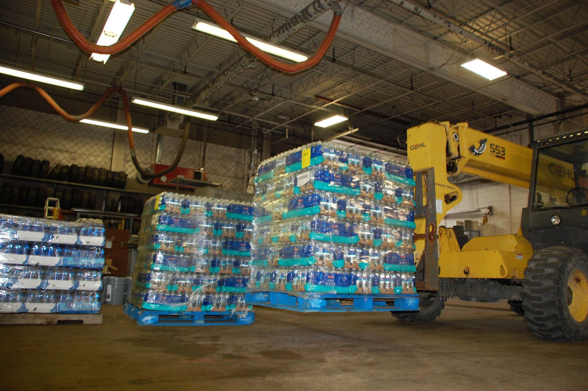 Pallets stacked in a warehouse next to a forklift